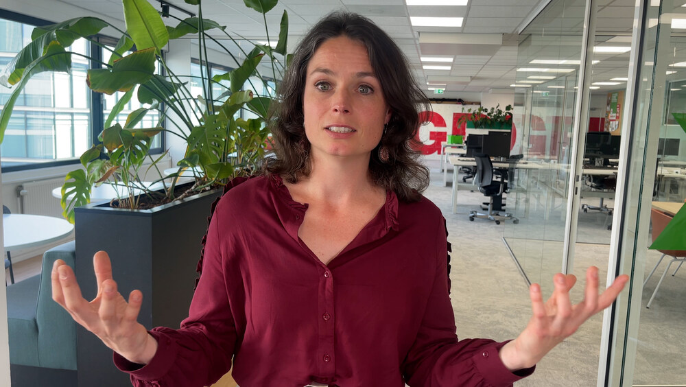 Katinka Eikelenboom staat in een rood shirt iets uit te leggen.