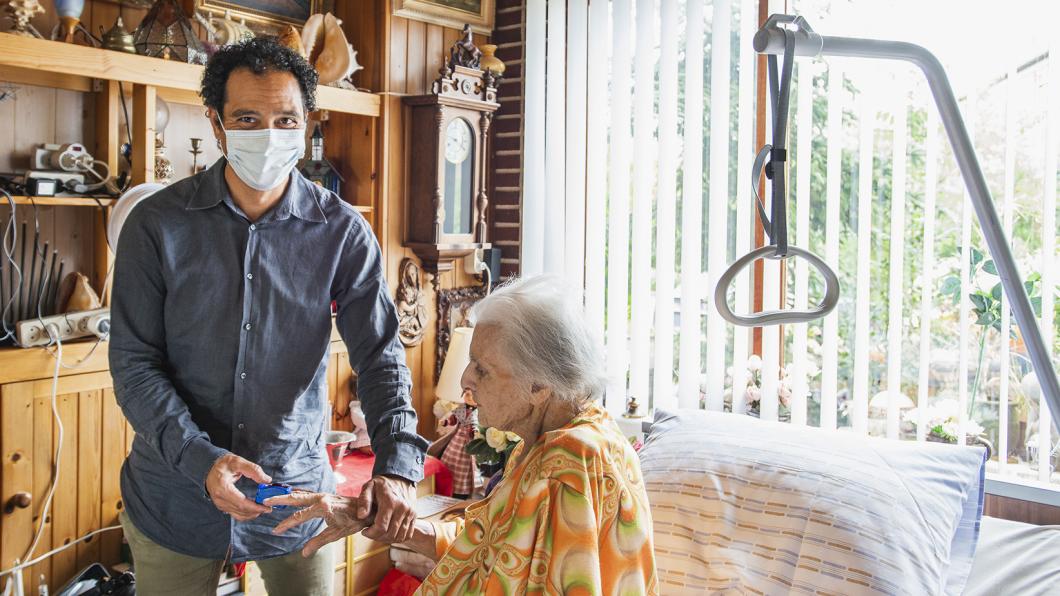 Een man zorgt voor zijn oudere moeder thuis