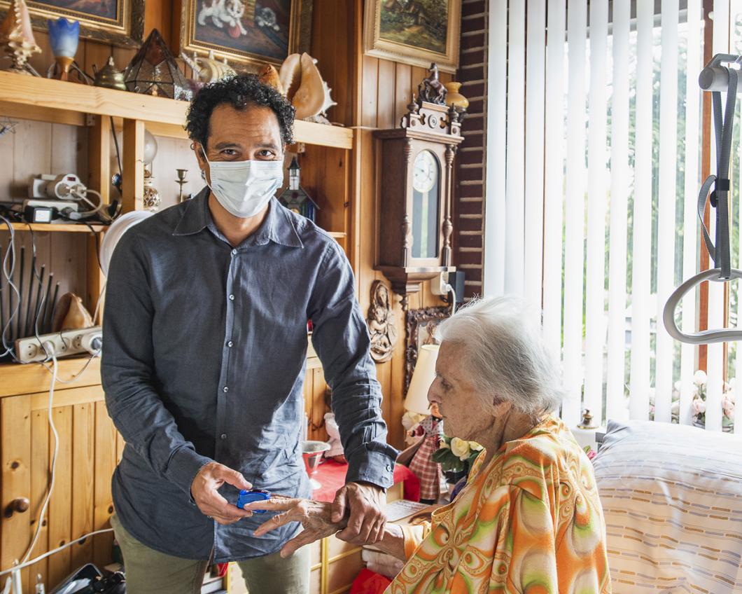 Een man zorgt voor zijn oudere moeder thuis