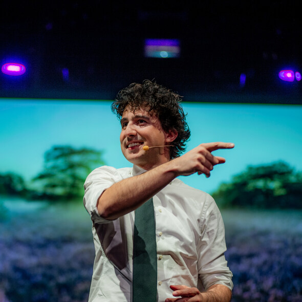 Jesse Klaver staat in een zaal, wijzend naar iets buiten beeld