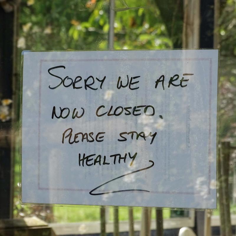 Brief op de winkelruit waarop staat dat de winkel gesloten is vanwege corona