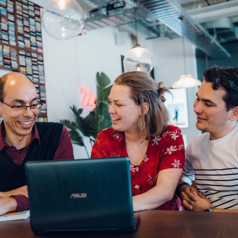 Foto van cursisten die naar een laptop kijken